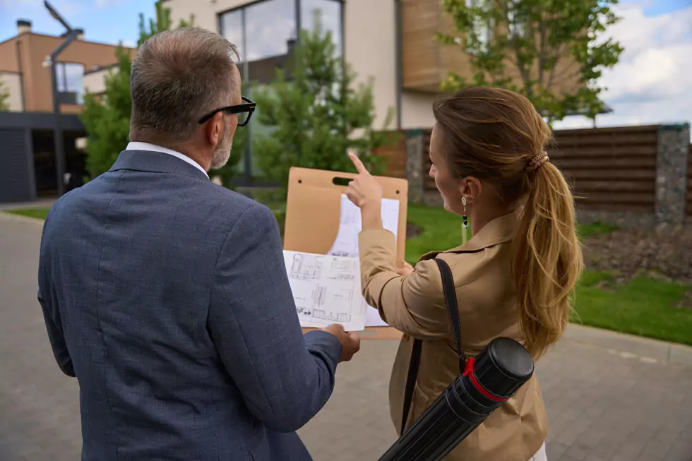 Besichtigung Markler zeigt einer Wohnungsinteressentin ein Haus