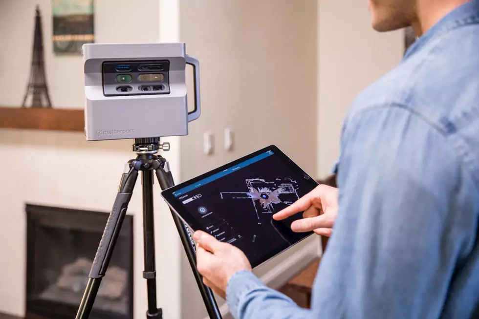 matterport select Mann tippt auf einem Tablet und stellt die Kamera für die Anfertigung von 3D Haus-Ansichten ein